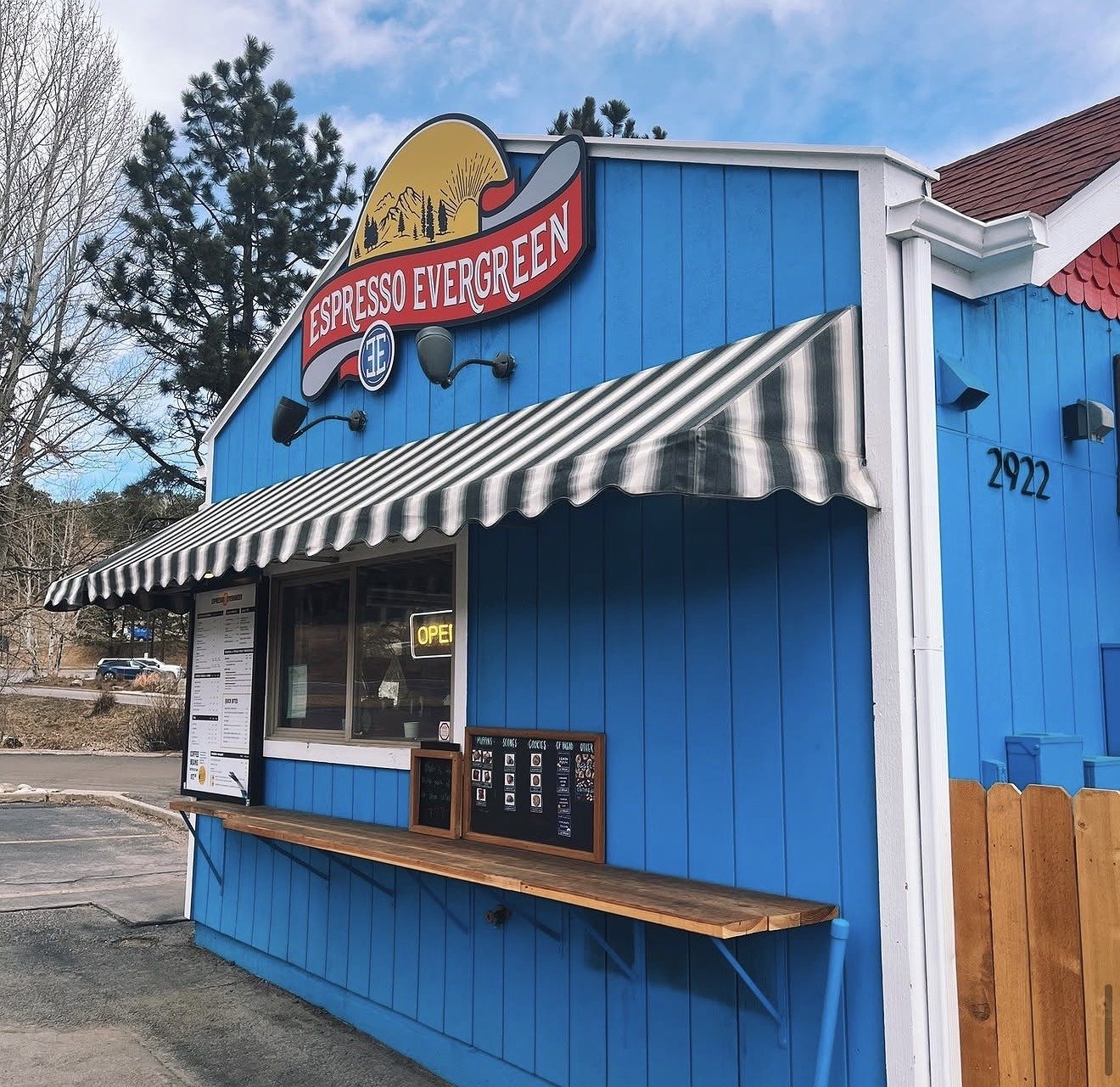 Espresso Evergreen's drive-thru stand in the snow, with the sign lit up